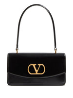 Black handbag with gold logo on a white background