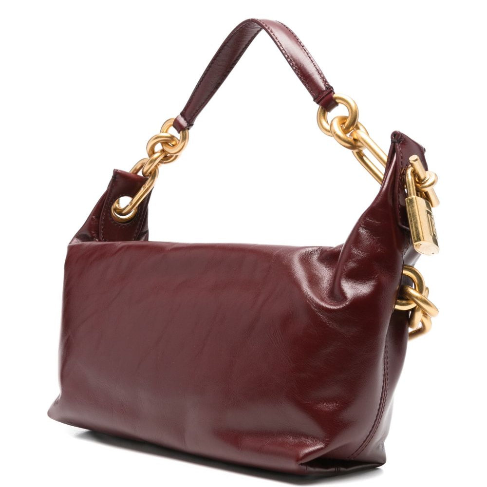 Brown handbag with gold hardware on a white background