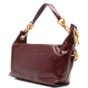 Brown handbag with gold hardware on a white background