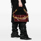 Person holding a burgundy handbag with gold chain detail against a white background