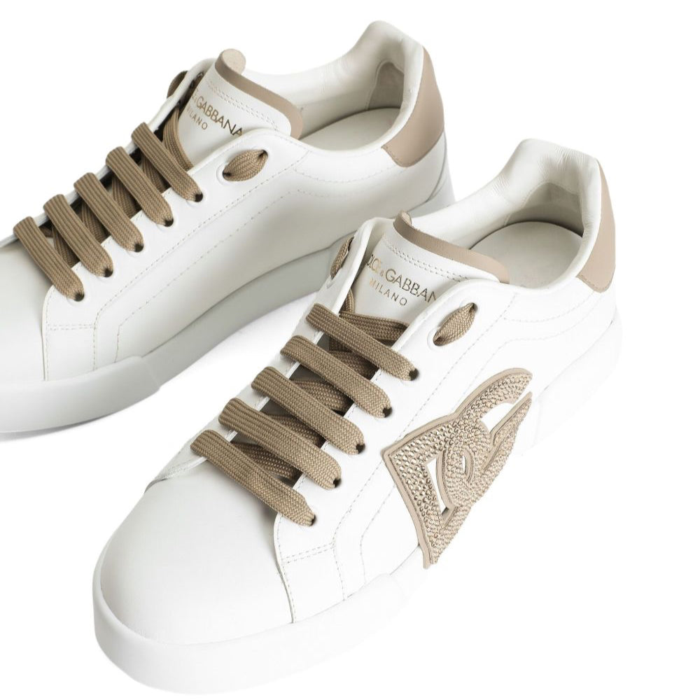 White sneakers with beige laces and accents on a white background