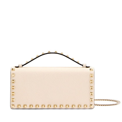 Beige handbag with gold studs on a white background
