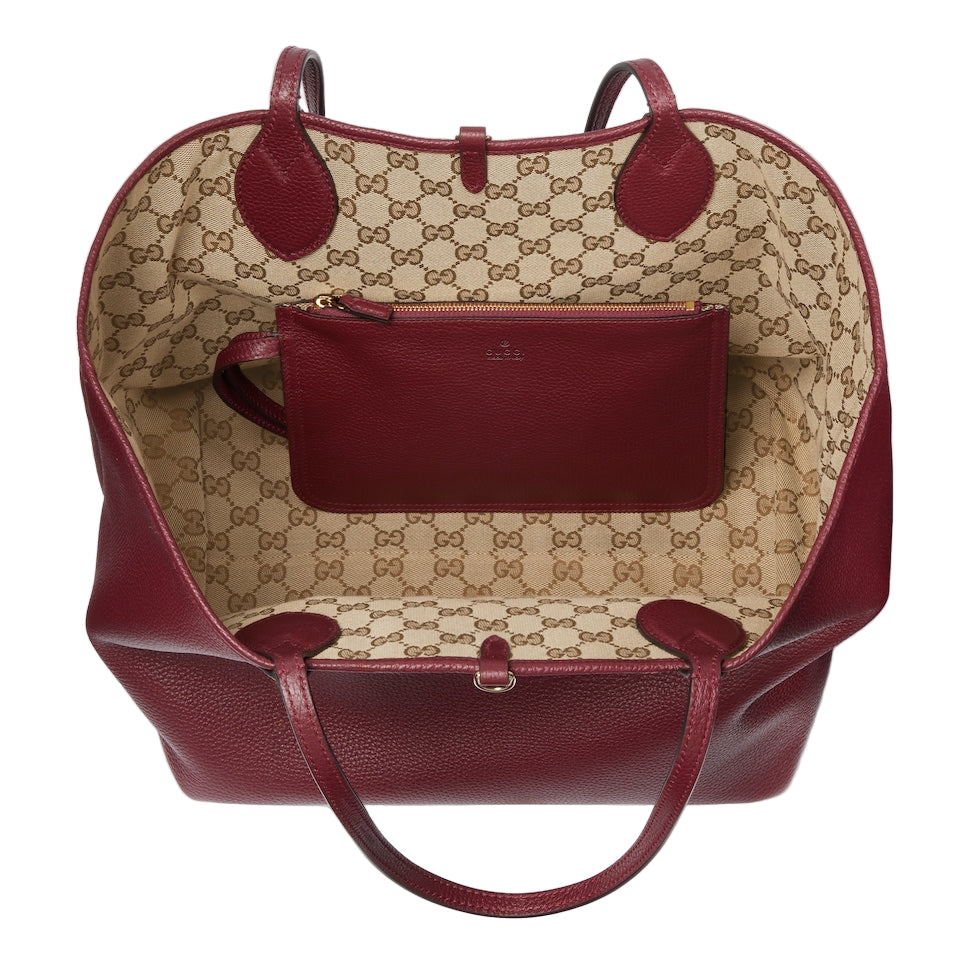 Designer handbag with a prominent brand logo on a light gray background