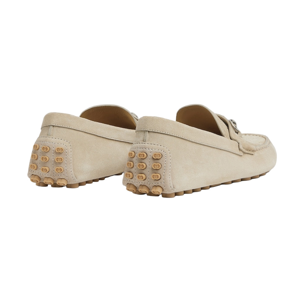 Pair of beige loafers with studded details on a light gray background