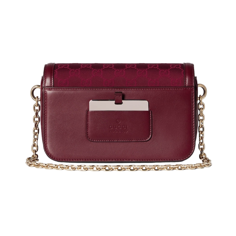 Maroon handbag with gold chain strap on a light gray background