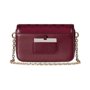 Maroon handbag with gold chain strap on a light gray background