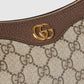 Close-up of a Gucci handbag with brown leather strap and gold logo.