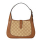 Brown handbag with a patterned flap on a light gray background