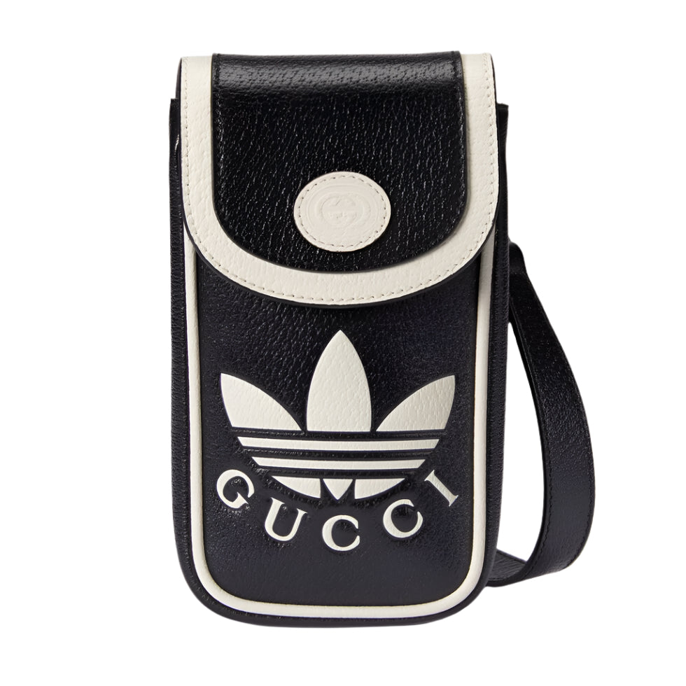 Black and white crossbody bag with Gucci and Adidas logos on a light gray background