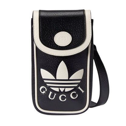 Black and white crossbody bag with Gucci and Adidas logos on a light gray background