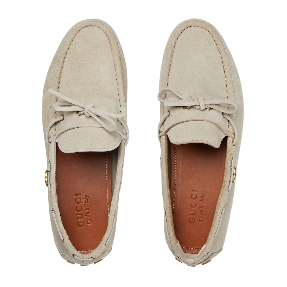 Pair of beige Gucci loafers on a white background