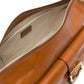 Brown leather bag with gold zipper and handle on a white background