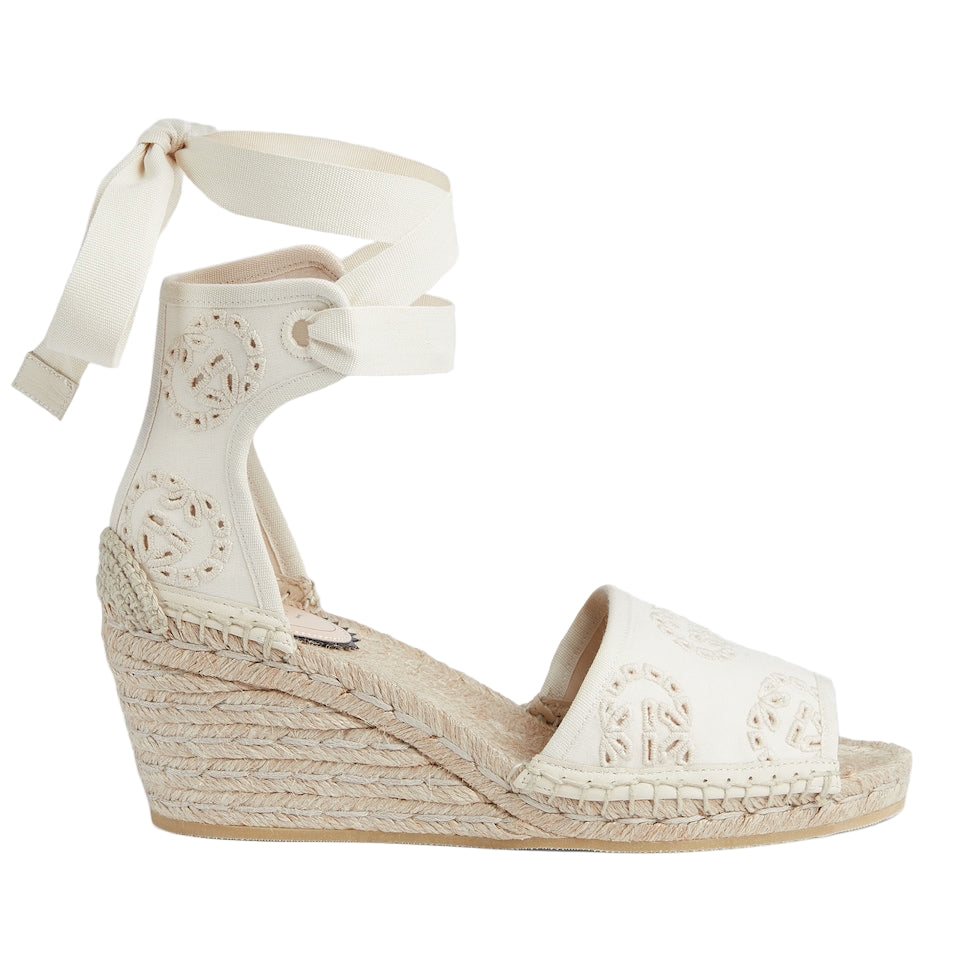 White wedge sandal with espadrille sole on a light gray background