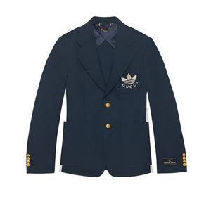 Navy blazer with gold buttons and a logo on a light gray background