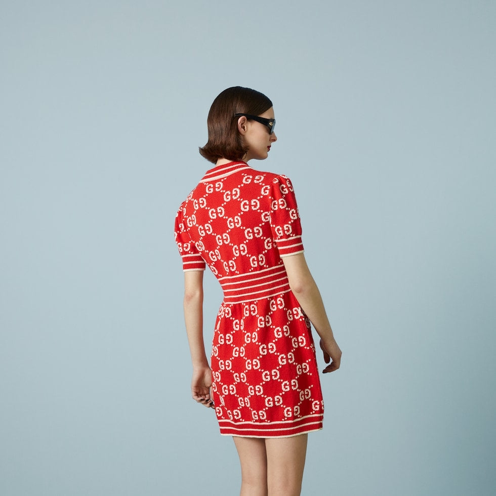 Woman wearing a red dress with a pattern on a light gray background