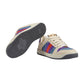 Beige sneaker with colorful stripes on a light gray background