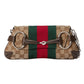Designer handbag with Gucci logo and color stripe on a light gray background