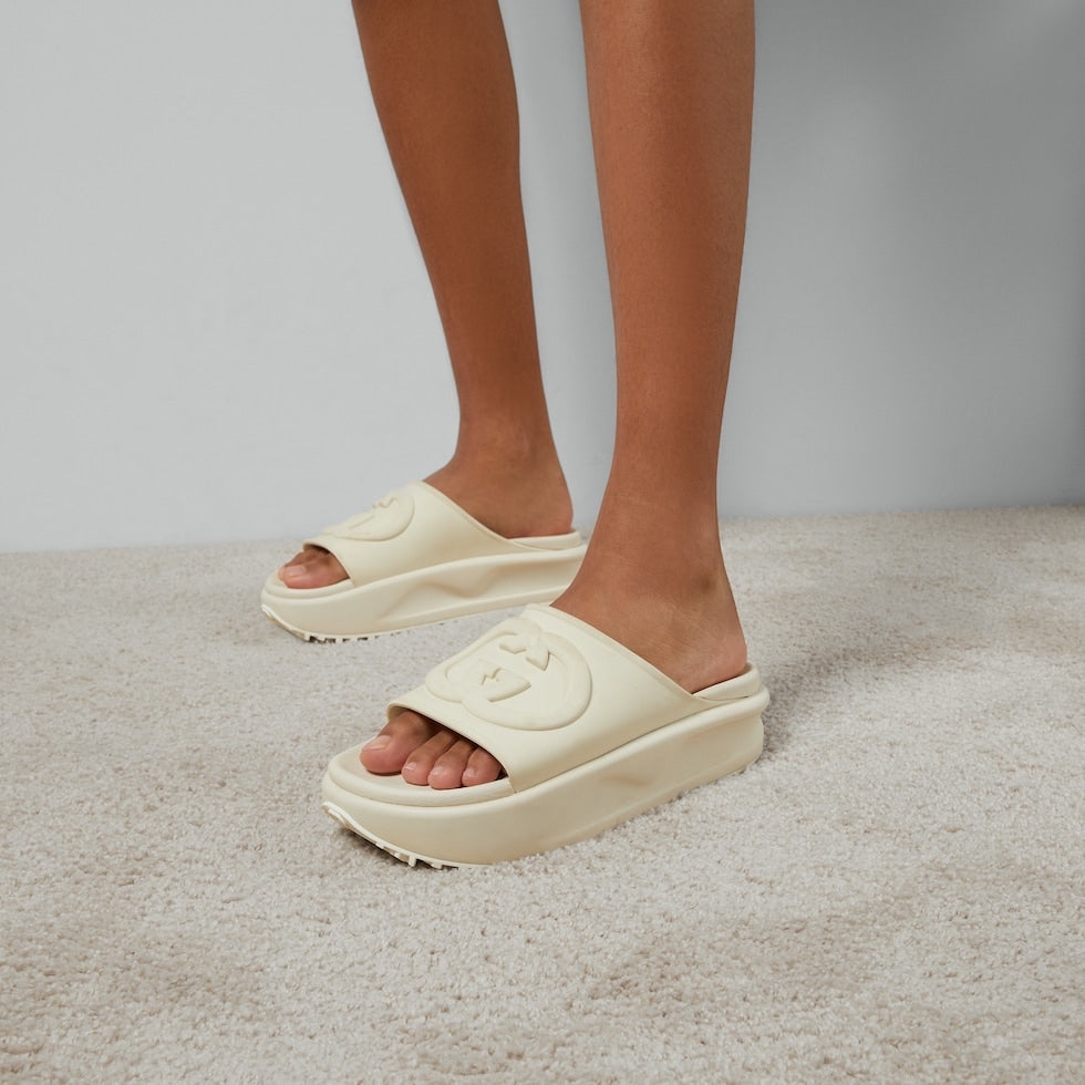Beige platform sandals worn on a neutral background
