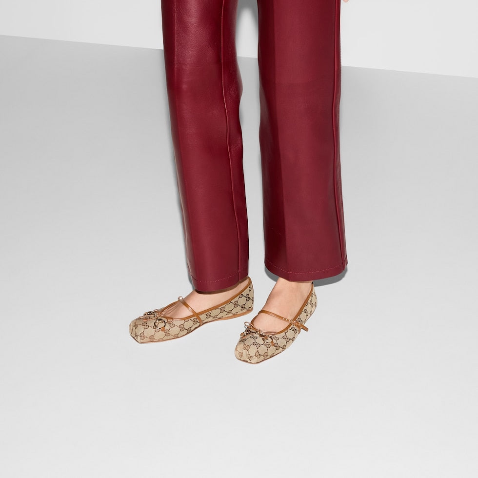 Patterned flats worn with red pants on a white background