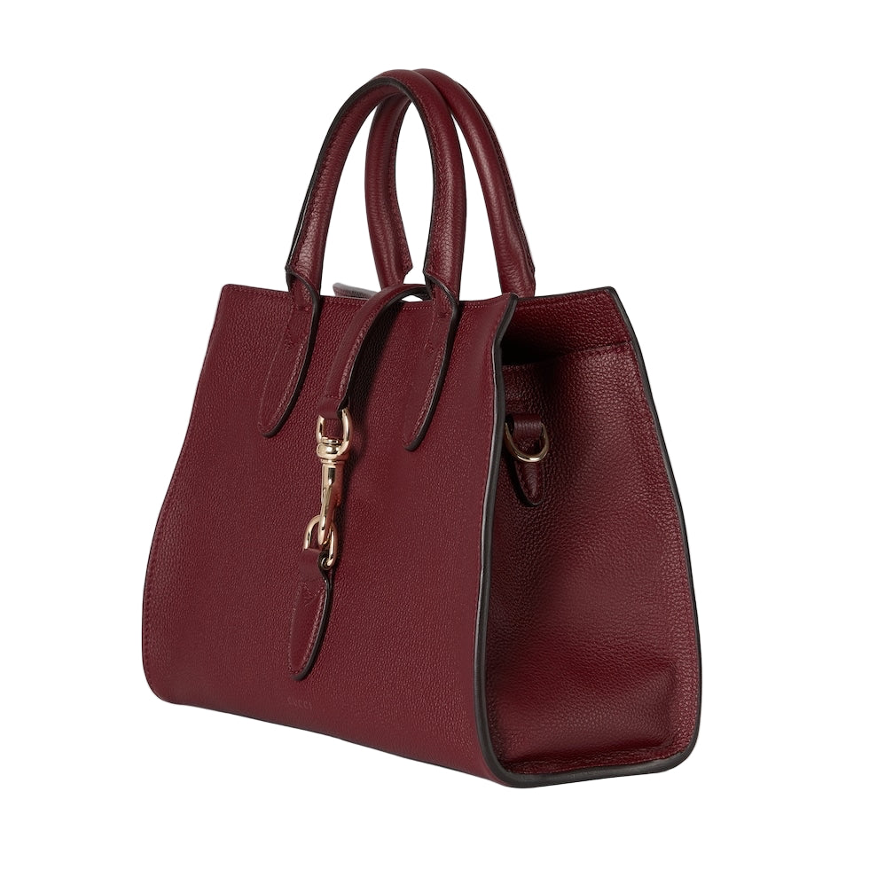 Red handbag with a gold clasp on a light gray background