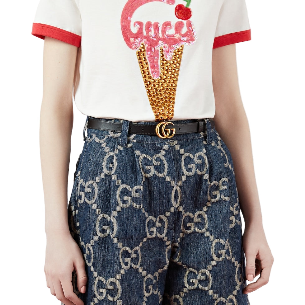 Person wearing a Gucci ice cream-themed t-shirt and GG patterned pants on a white background