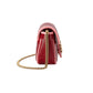 Red handbag with gold chain strap on a light gray background