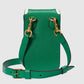 Green leather handbag with gold hardware on a light gray background
