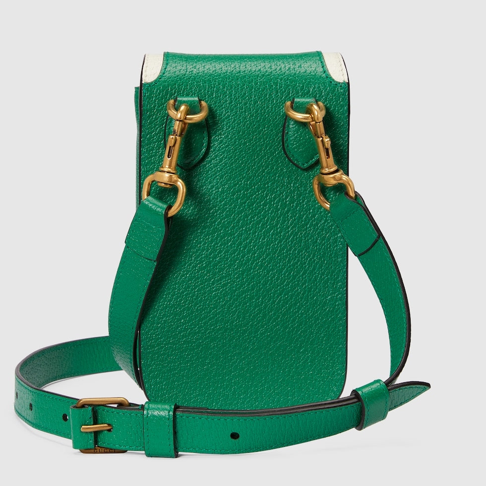 Green leather handbag with gold hardware on a light gray background