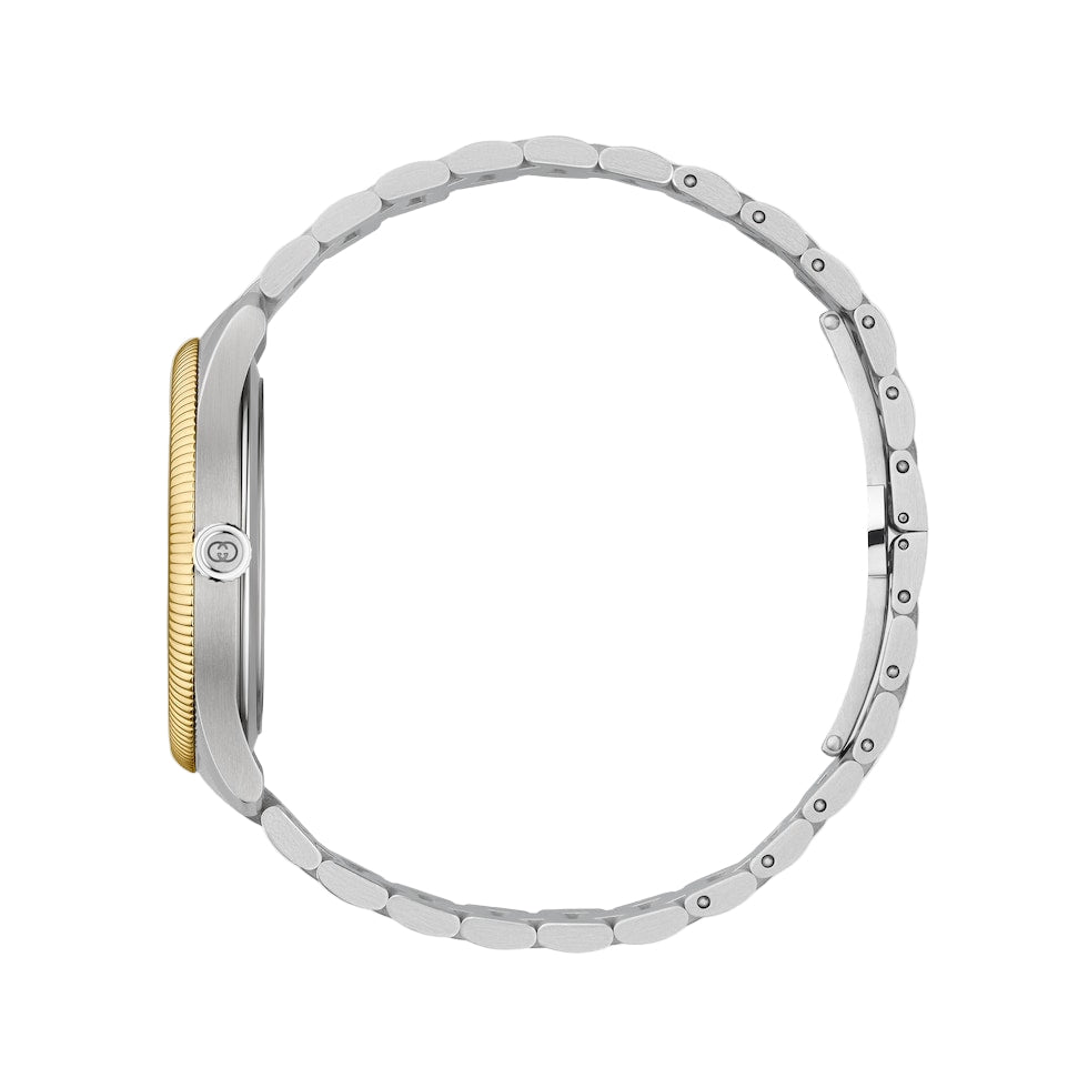 Close-up of a silver watch with a gold accent on a light gray background