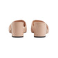 Pair of beige mules on a light gray background