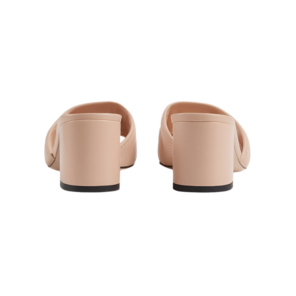 Pair of beige mules on a light gray background