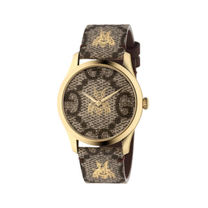 Gold watch with patterned brown strap on a light gray background