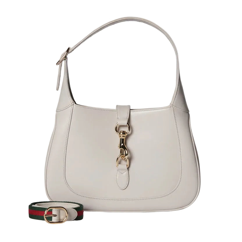 Light gray handbag with gold clasp on a light gray background