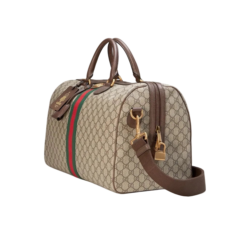 Designer handbag with monogram pattern and red and green stripe on a light gray background
