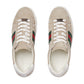 Pair of Gucci sneakers with signature green and red stripes on a light gray background