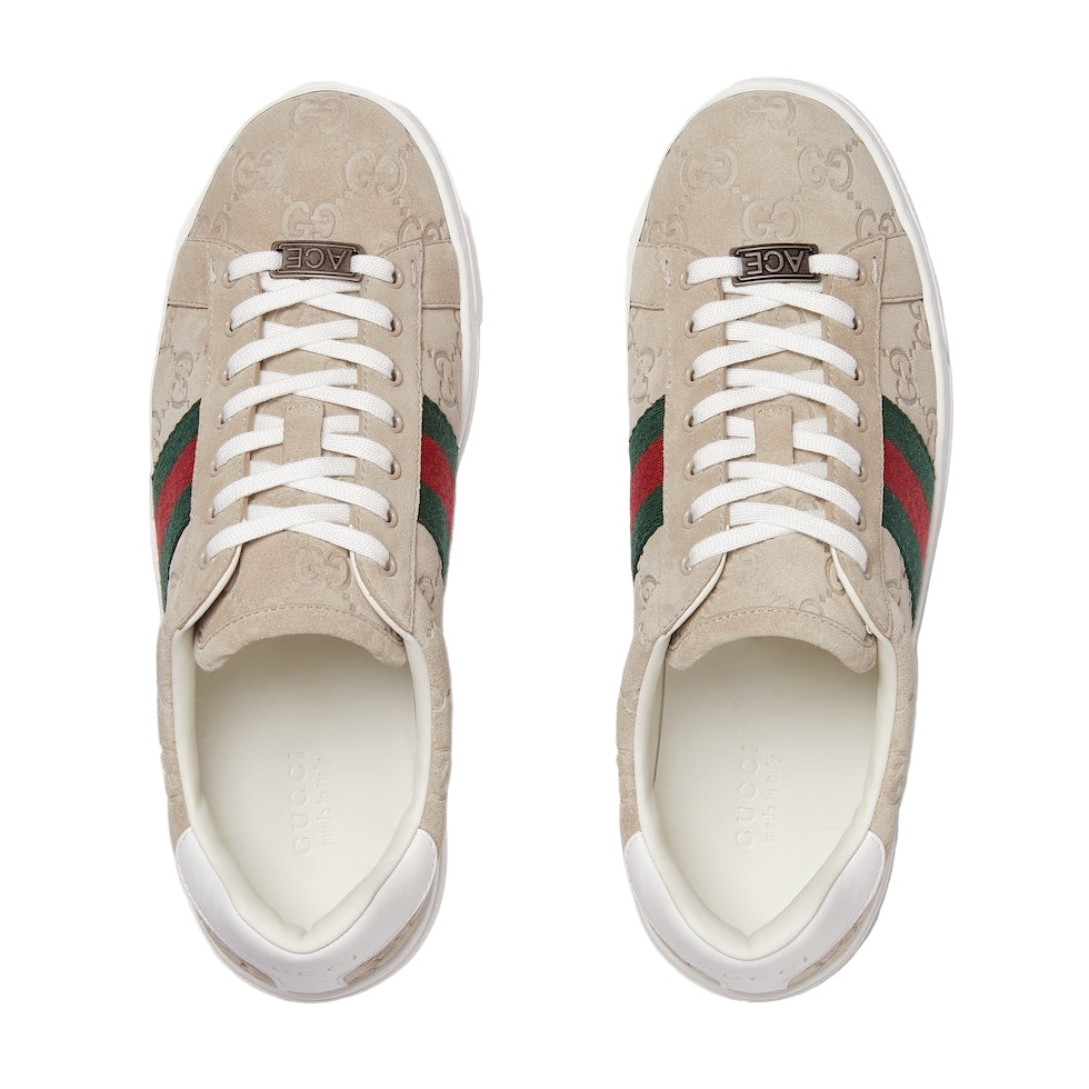 Pair of Gucci sneakers with signature green and red stripes on a light gray background