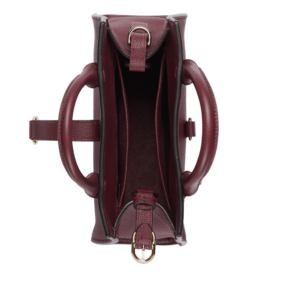 Maroon handbag with gold hardware on a light gray background