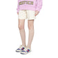 Person wearing a pink sweatshirt with 'Exotica' text, white shorts, knee-high socks, and colorful sneakers on a light gray background.