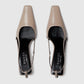 Pair of Gucci beige high heels on a light gray background