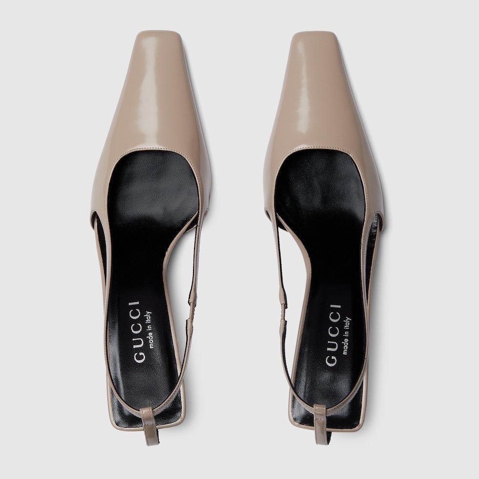 Pair of Gucci beige high heels on a light gray background