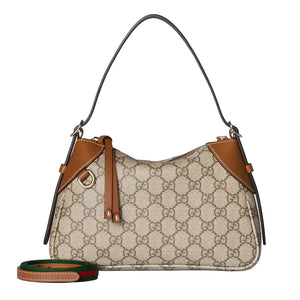 Designer handbag with brown leather accents on a light gray background