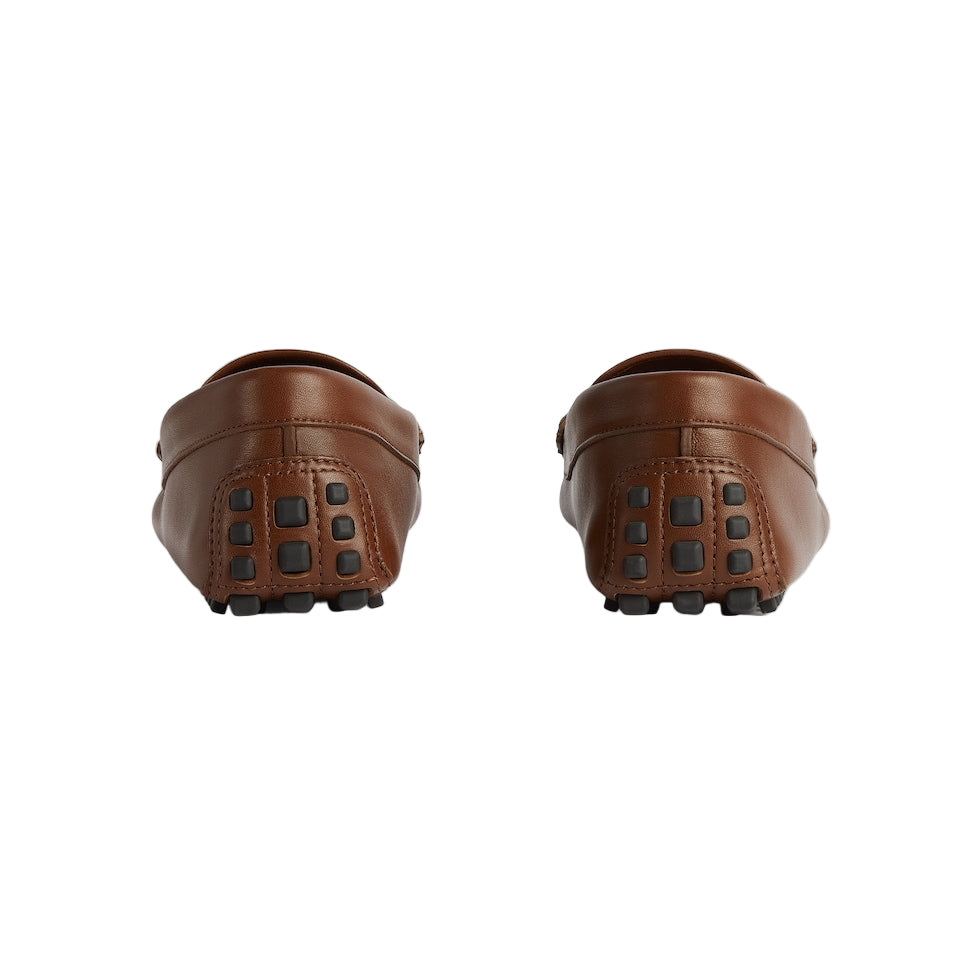 Pair of brown leather loafers on a light gray background