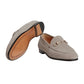 Gray loafer shoe with gold buckle on a light gray background
