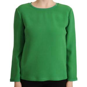 Green long-sleeve top worn by a person on a white background