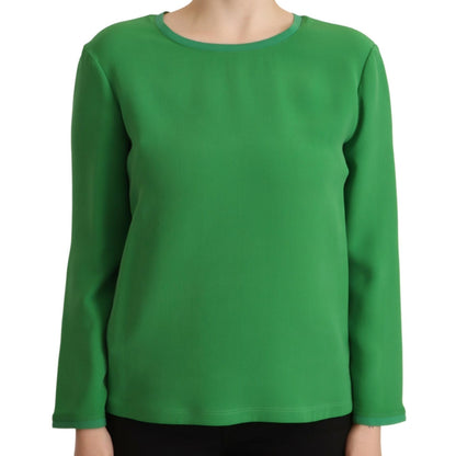 Green long-sleeve top worn by a person on a white background