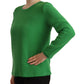 Green long-sleeve top worn by a person on a white background