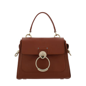 Brown handbag with gold ring detail on a white background