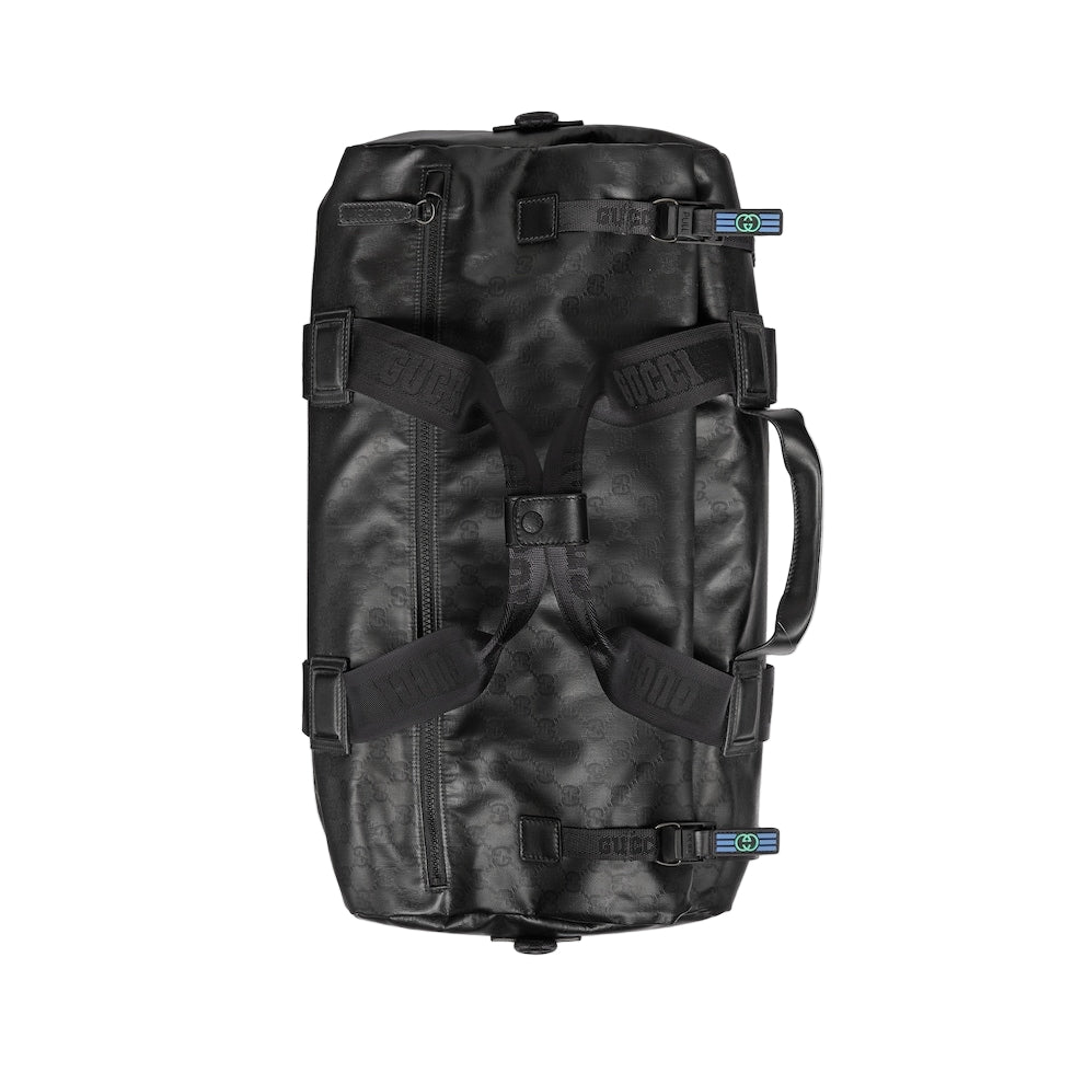 Black duffel bag with multiple straps on a light gray background