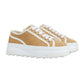 Tan sneakers with white laces and sole on a light gray background