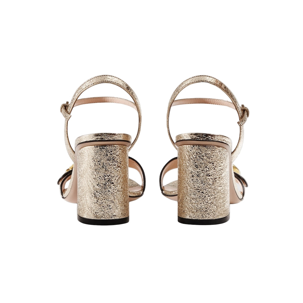Gold glittery high-heeled sandals on a white background